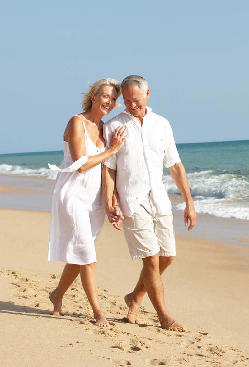 older couple walking on beach